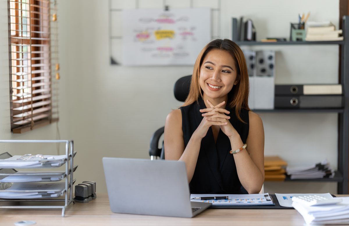 Professional virtual assistant working on a laptop in a bright office
