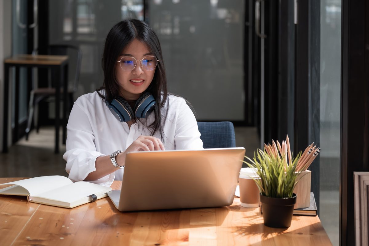 Business professional focused on her laptop in a bright workspace